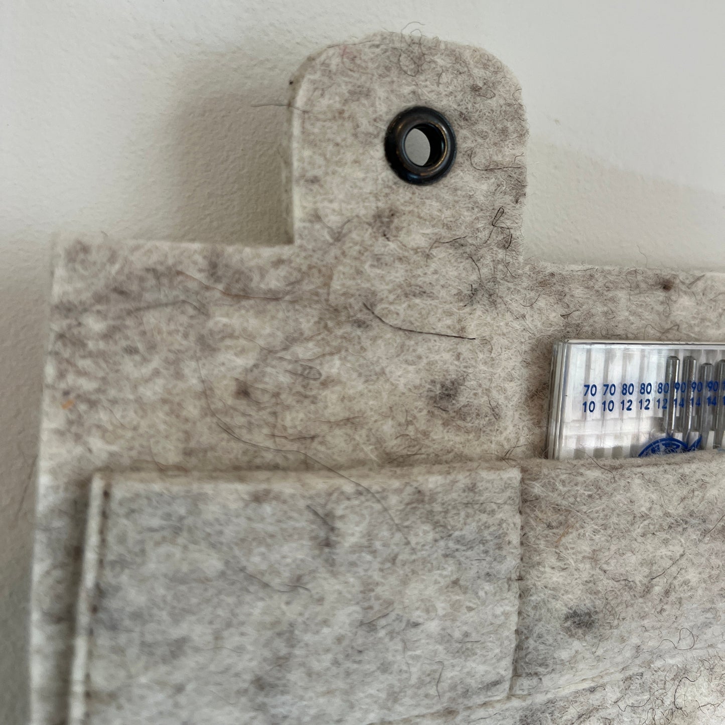 Grey felt with a button and a small pocket on a white background