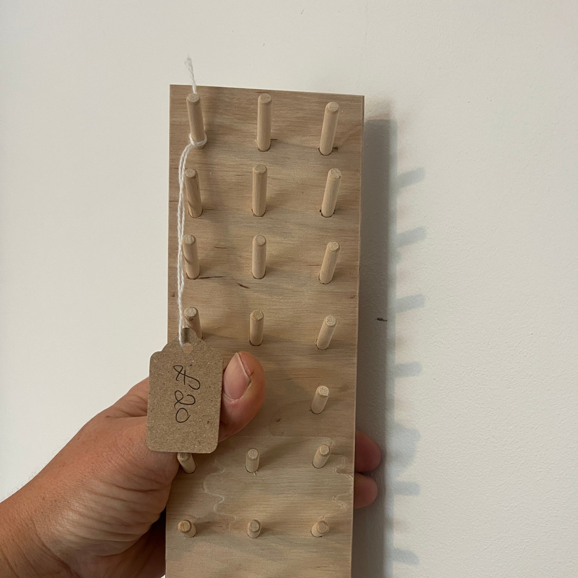 Wooden pegboard being help in a hand
