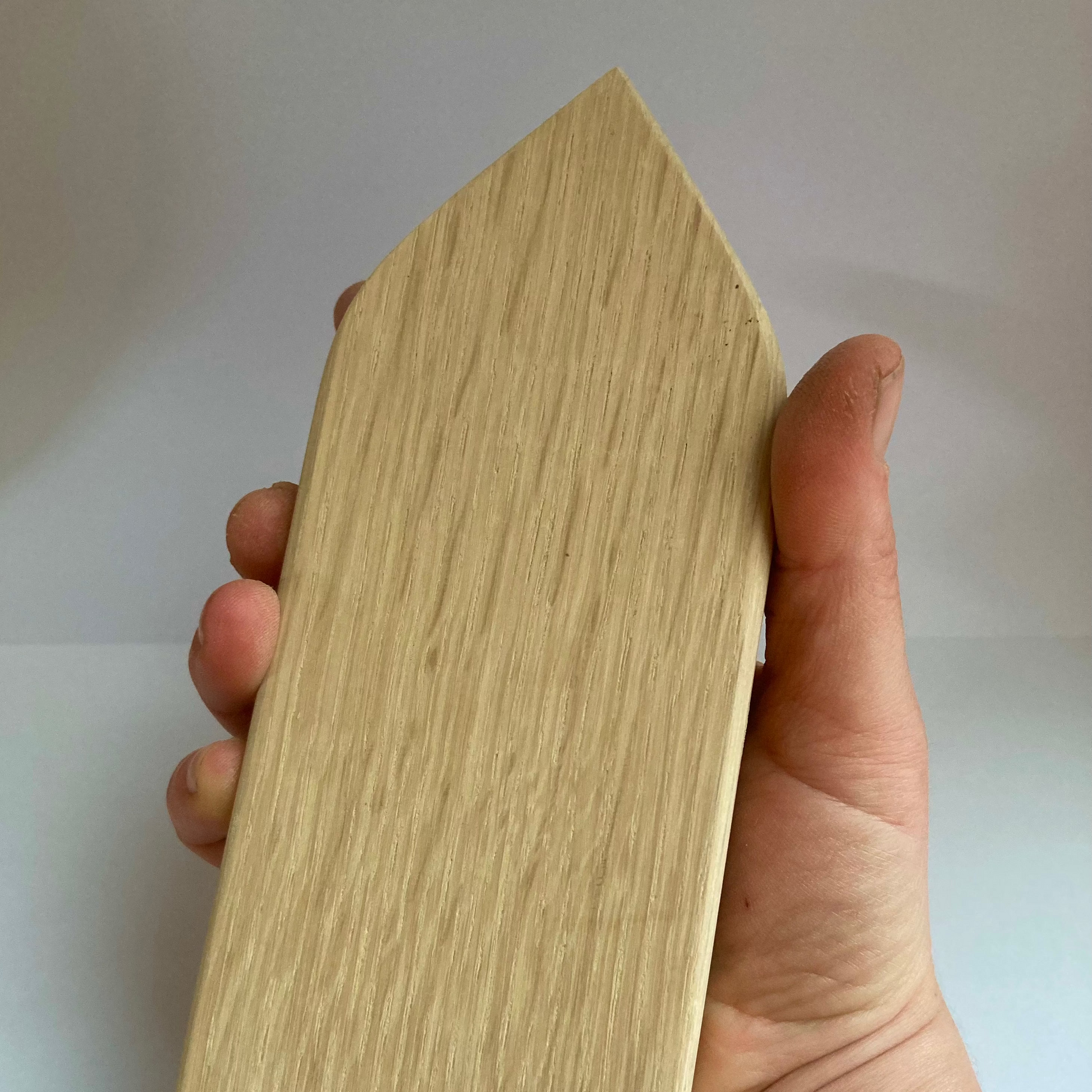 Hand holding a tailors clapper pressing tool sewing tool
