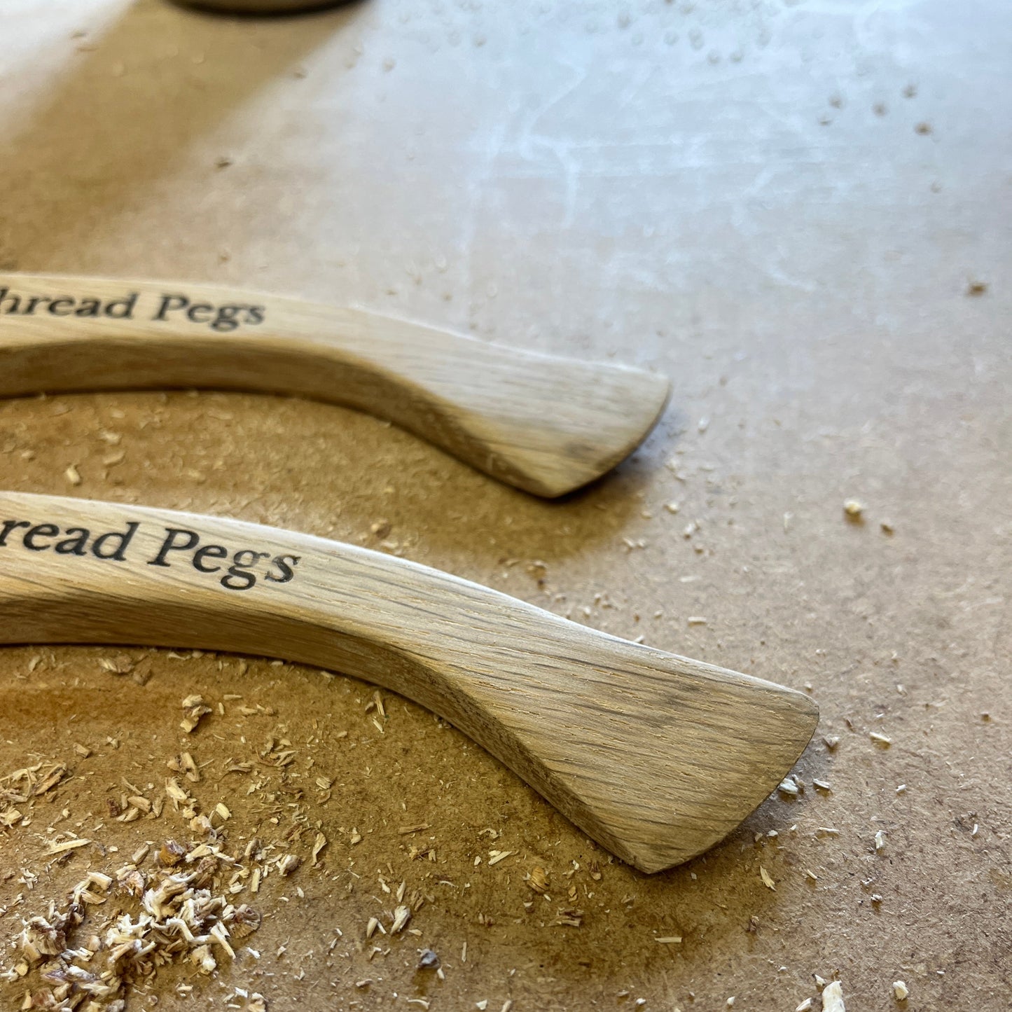 Two wooden Hera Markers with Thread Pegs text on a textured surface.