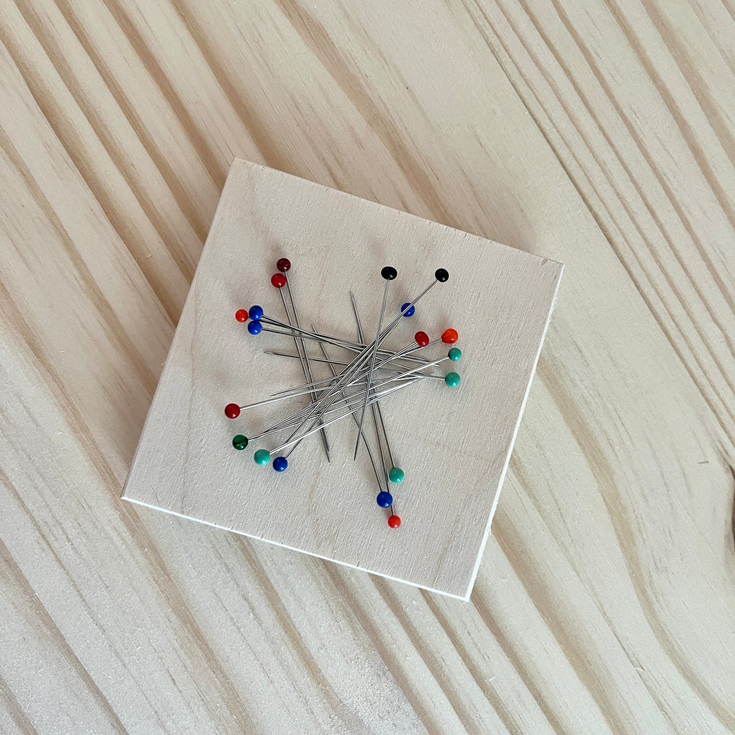 Magnetic wooden pin holder on a wooden surface