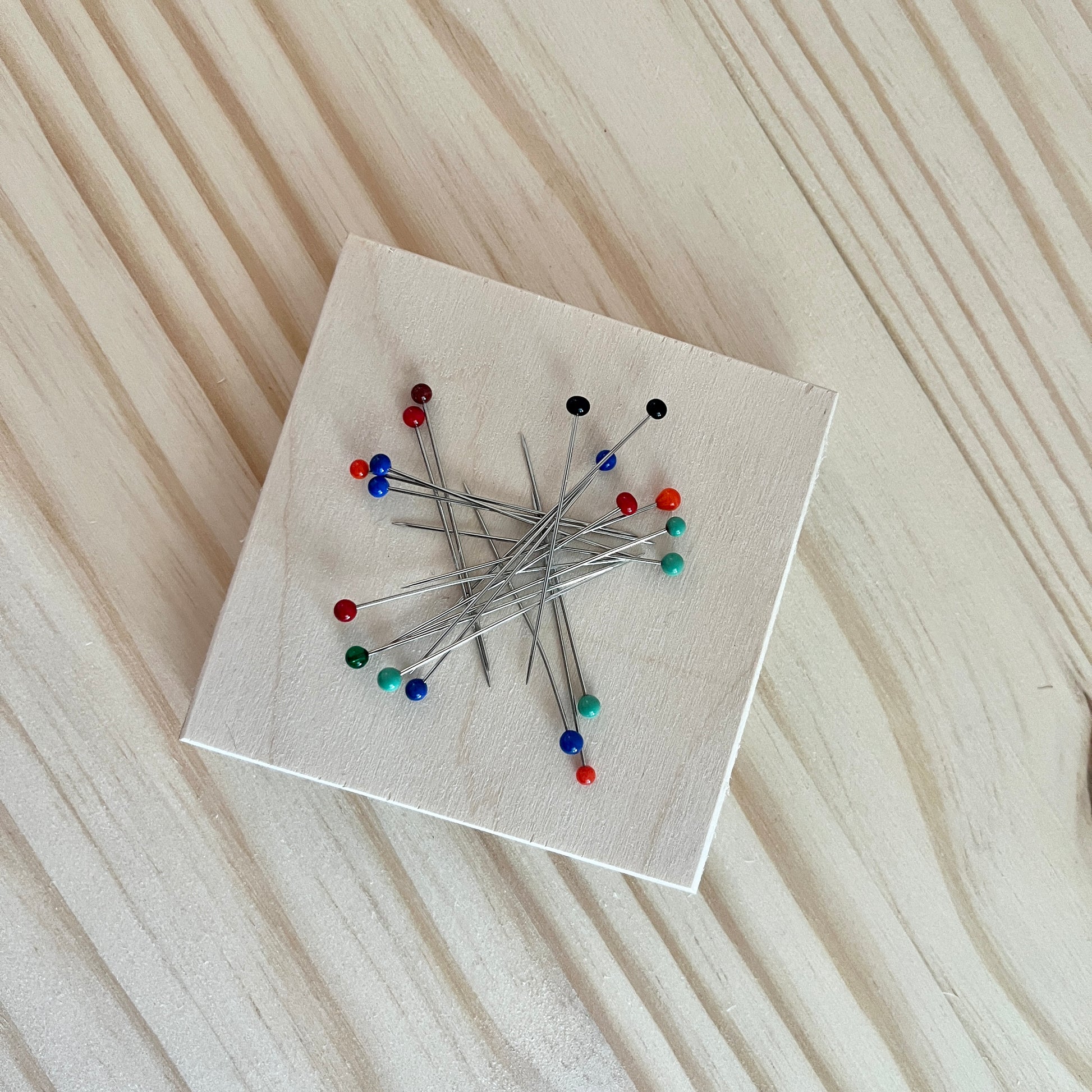 Magnetic wooden pin holder on a wooden surface